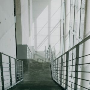 A long hallway with metal railings leading up to a building