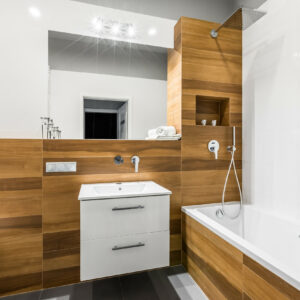 Modern, wooden bathroom with mirror, basin, toilet and bathtub